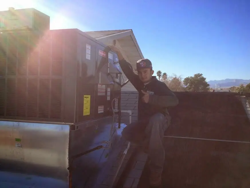 HVAC technician performing AC Tune-Up on a rooftop unit in Richland